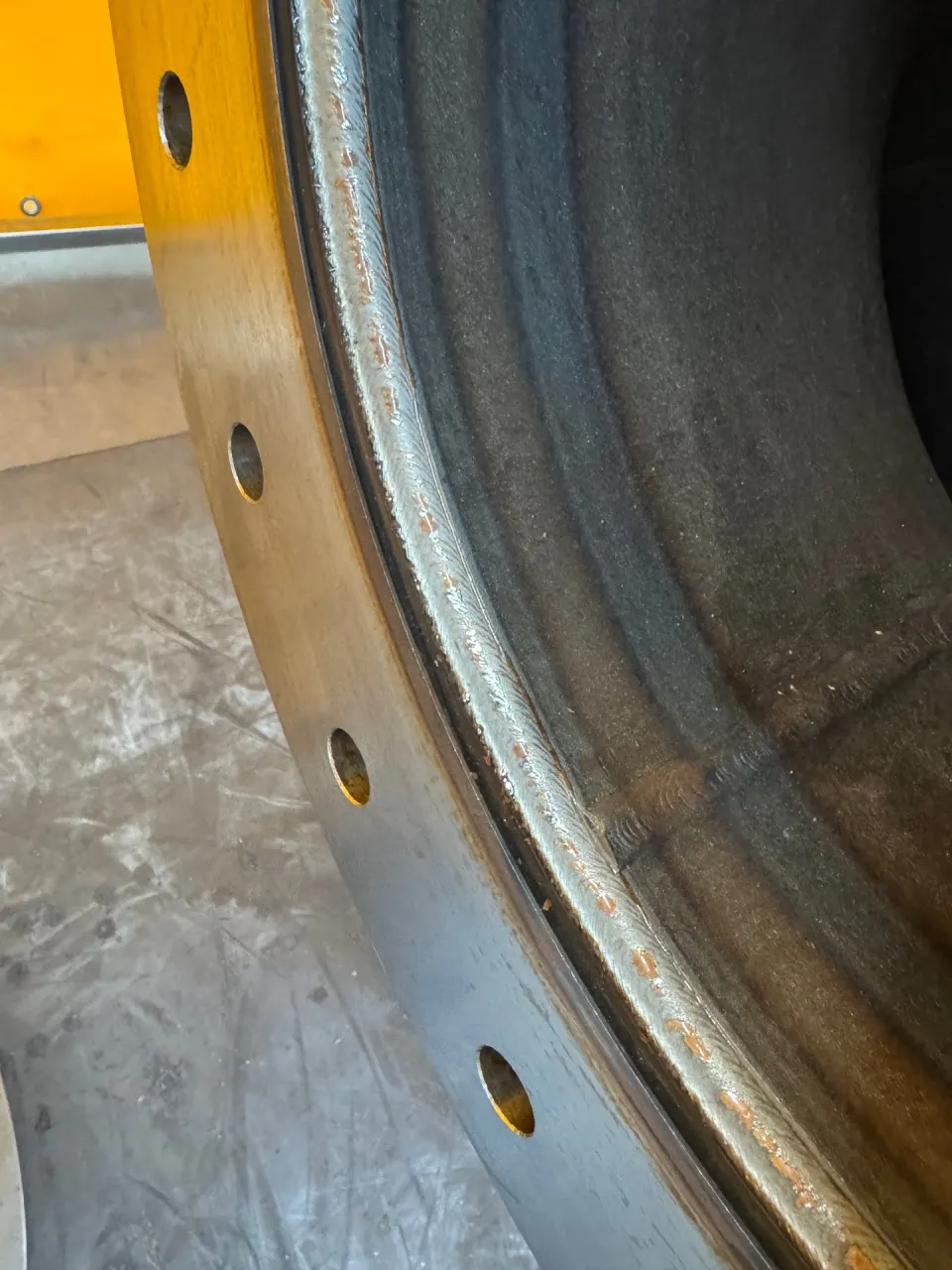 Robot-welded elbow-to-flange girth seam with an even ripple pattern and no undercut